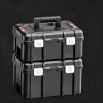 Stacked set of heavy-duty waterproof kayak battery boxes on dark solid background